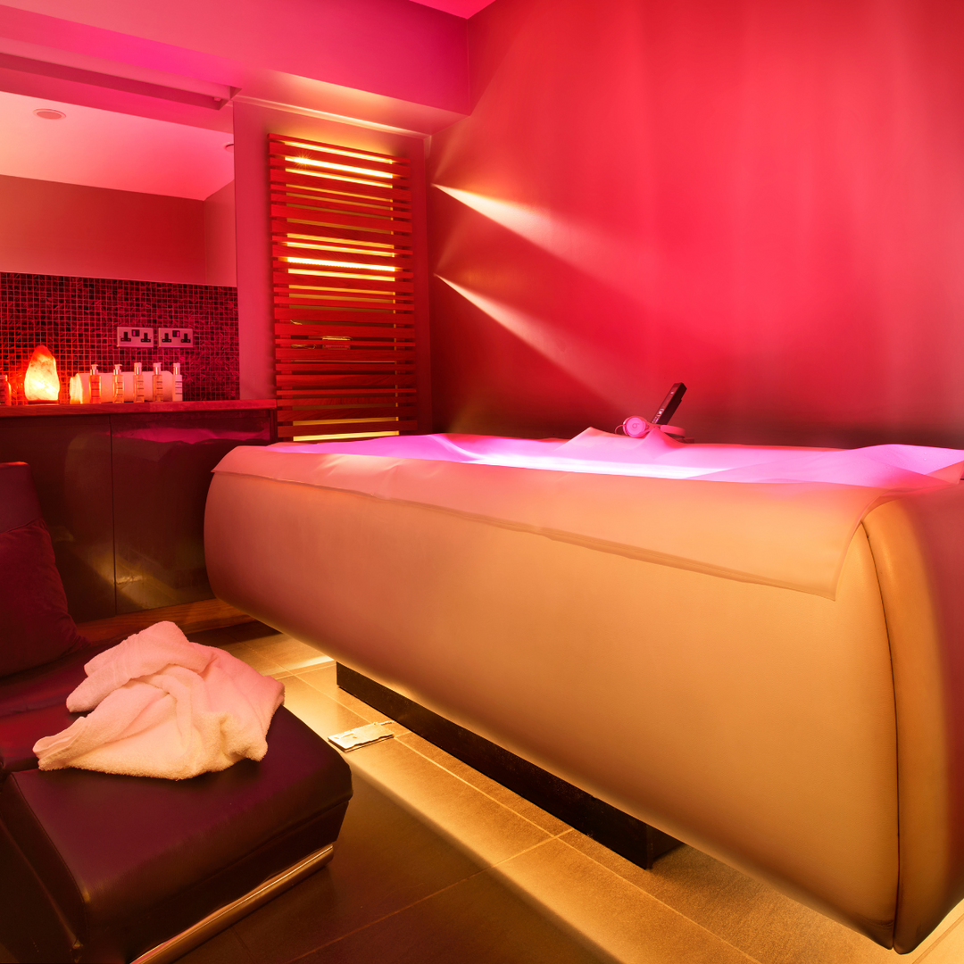 Zerobody dry float bed in a private room lit in soft pink light at PURE