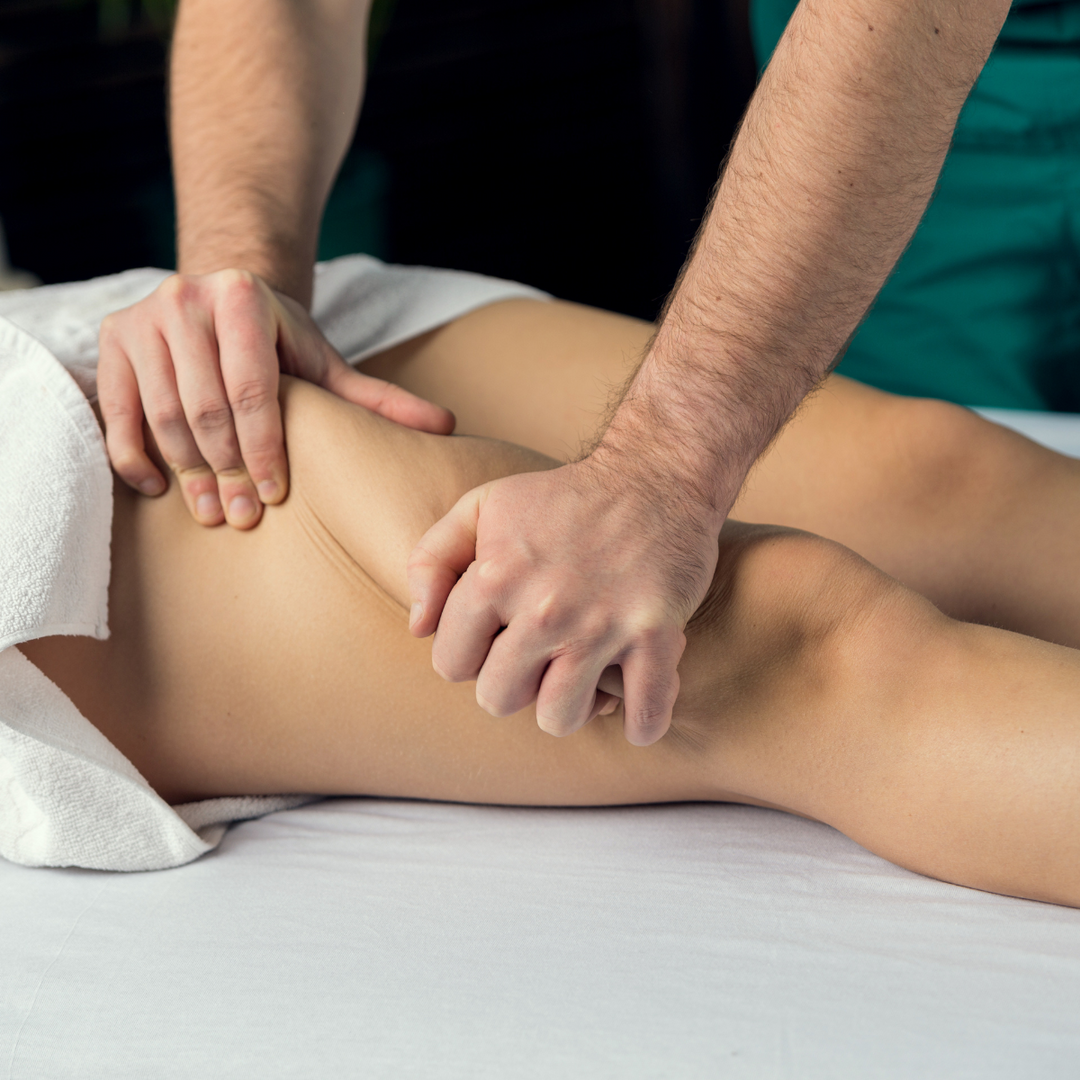 Therapist's hands working along the back of a guest's leg during a lymphatic drainage massage at PURE